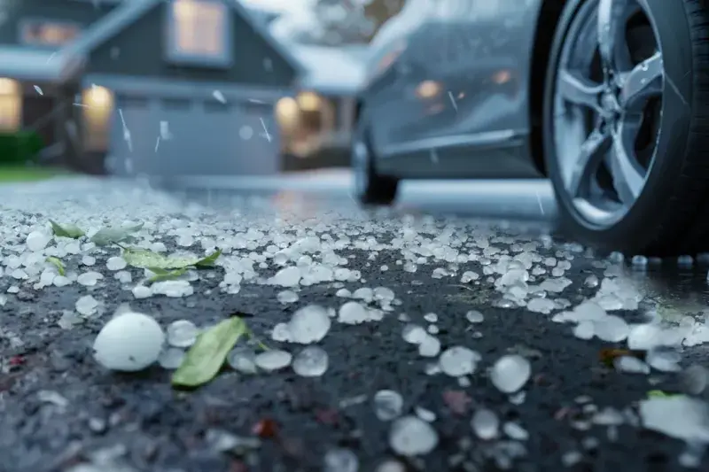 Hail stones in focus with a blurred home in the background